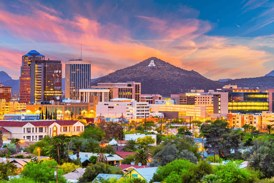 A vibrant sunset over downtown Tucson, Arizona, with the iconic A-mountain in the background.